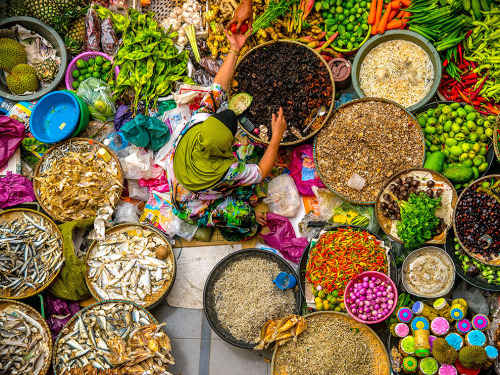 natgeotravel:  Kota Bharu, Malaysia Fresh produce and baskets of fish surround a woman at the Siti K