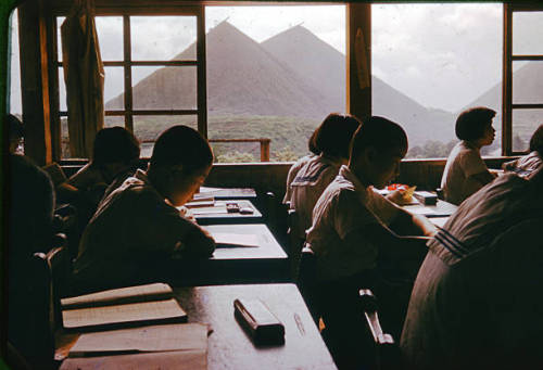 s-h-o-w-a: Students study at a classroom while spoil banks are seen on the background at a coal mine