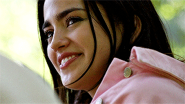 A Surprised Brow Rises At His Comment , Her Lips Curving Into A Sly Smile As She Settles Back Into The