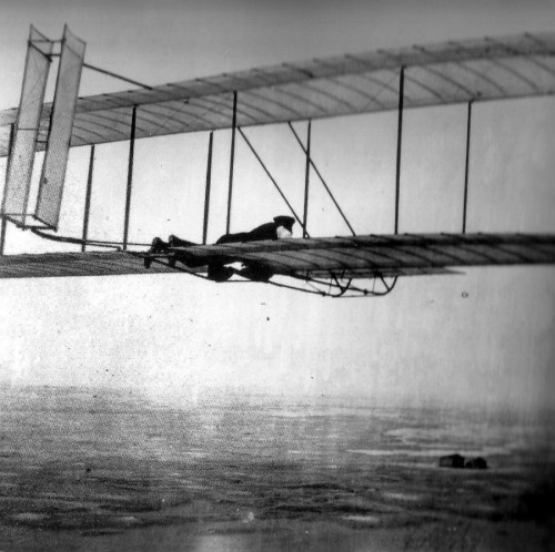 A Wright brother flying their glider, Kitty Hawk, 1902.