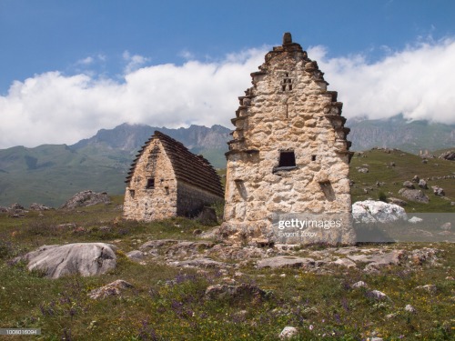 Old Ossetian mausoleums with the Caucasus Mountains on the background. North Ossetia-Alania, Russia.