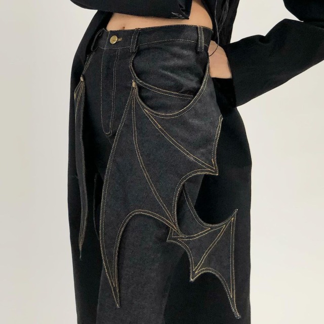 black jeans with denim bat wings stitched near the pockets