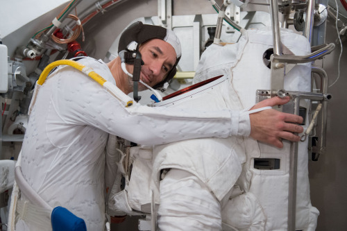 ESA Astronaut Luca Parmitano gently hugs the outer shell of his EMU spacesuit during a fit check at 