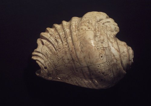 Shell trumpet, helpfully engraved with a man blowing a shell trumpet, just in case archaeologists we