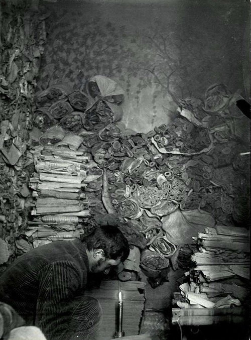 Paul Pelliot examining manuscripts in the Library Cave, Mogao Caves,China (Qing dynasty), 1908 (phot