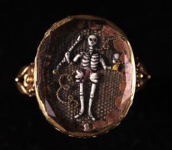 aleyma:  Mourning ring with a skeleton holding an hourglass on a background of woven hair. Made in Europe in 1690 (source). 