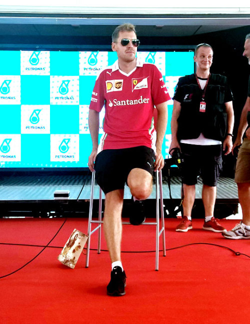 Seb at the Malaysian GP Fan Forum ft. the trophy I made for him in its bag by his feet