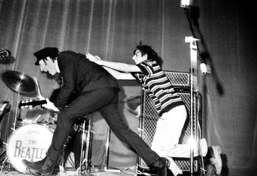 John Lennon Continues To Play The Guitar As He Evades A Young Fan Who Wants Lennon's Yachting-style Cap