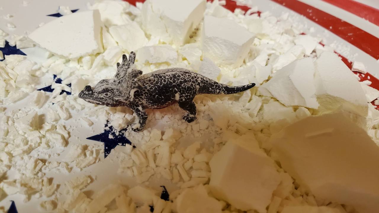 Dinosaur surrounded by shattered cornstarch mixture