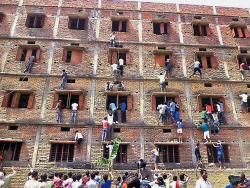 blazepress:  Parents climb the wall of a building to pass cheat sheets to students sitting an exam in Hajipur, Bihar, India.