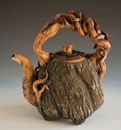 cookpot: [id: Photo of a teapot designed to look like it was made from a tree trunk with woven roots