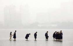 unearthedviews:  Wuhan, China: Students in graduation robes stand on a stone bridge submerged by floodwaters on Donghu Lake Darley Wong /Reuters 