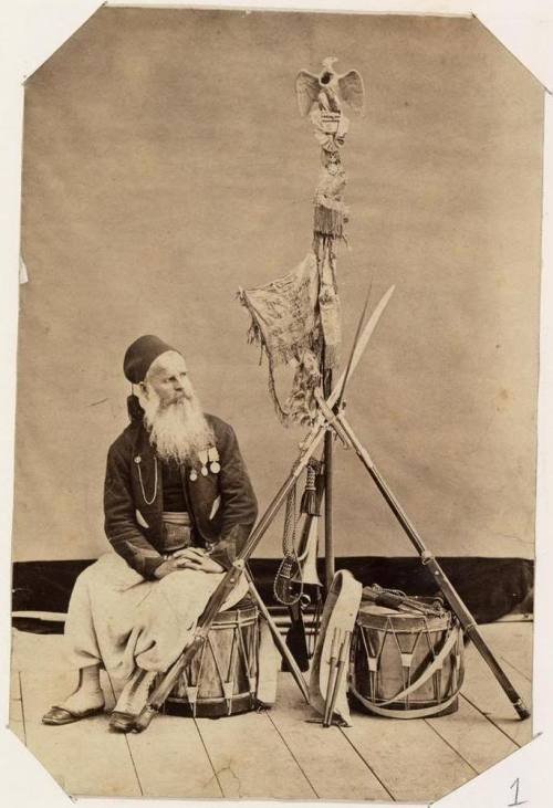 A French soldier posing with the Imperial Eagle and battle standard of the 2nd French Zouave Regimen