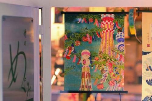 A simple yuzen washi tapestry depicting tanabata was hanging in a shop window on a hill leading up t