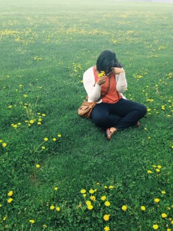 Throwing up peace signs in a field full of weeds.