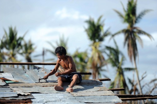 InFocus: Editor’s Picks Global News A Filipino man repairs his roof in typhoon-ravaged Tacloban city