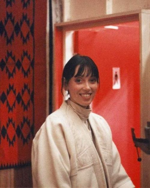 retroetic: An unpublished photo of Shelley Duvall standing outside the red bathroom set of The Shini