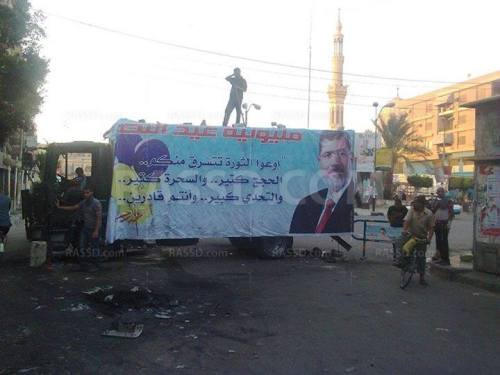 thebloodyreaper:  RNN: the protesters in Beni-Seuf close off the entrances to their sit-in square with the police vehicles they over-took and hang banners supporting Morsi on them.