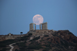 20aliens:The full moon rises behind the columns of the ancient marble Temple of Poseidon at Cape Sounion, southeast of Athens, on the eve of the summer solstice on June 20, 2016. The temple located on a promontory at Cape Sounion, about 70km (45 miles)