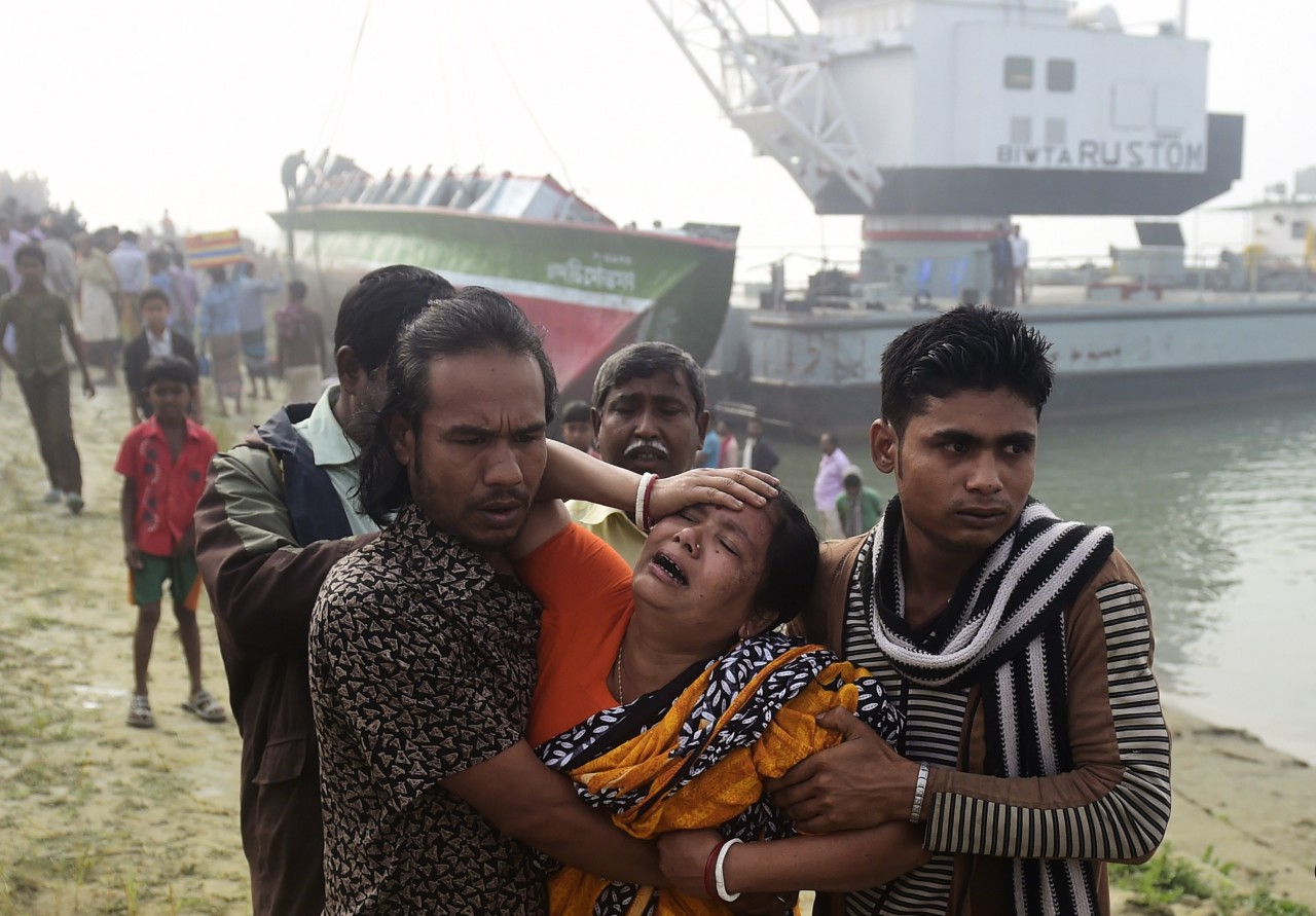 BANGLADESH. Una multitud observa el ferry naufragado en el Río Padma. Las autoridades informaron de 68 el número de muertos por el hundimiento ayer de un ferry con cerca de 200 pasajeros, tras colisionar con un carguero, en un río en el centro de...