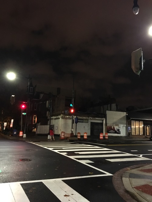 Clouds rolling past, flanked By glowing street lamps, focus On the buildings shell