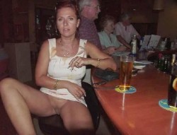 carelessinpublic:In a short dress inside a bar and showing her bottomless pussy