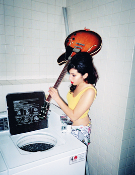 amyjdewinehouse:Amy Winehouse washing her guitar and vacuuming the pavement, 2003