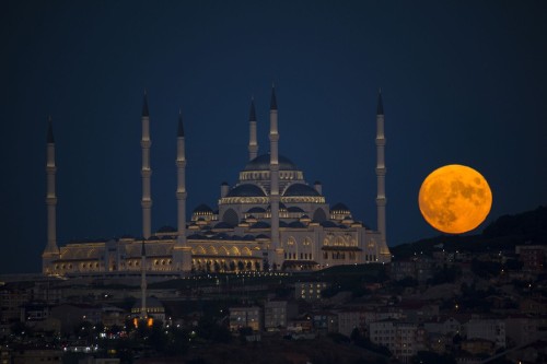 A full moon rises over Camlica Mosque, in Istanbul, Turkey. Isa Terli