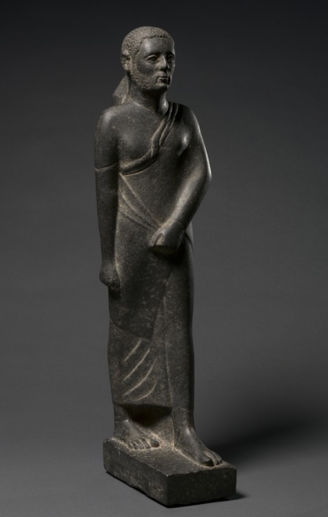 Statue of a ManThis striding figure represents a very late development in Egyptian sculpture and a f