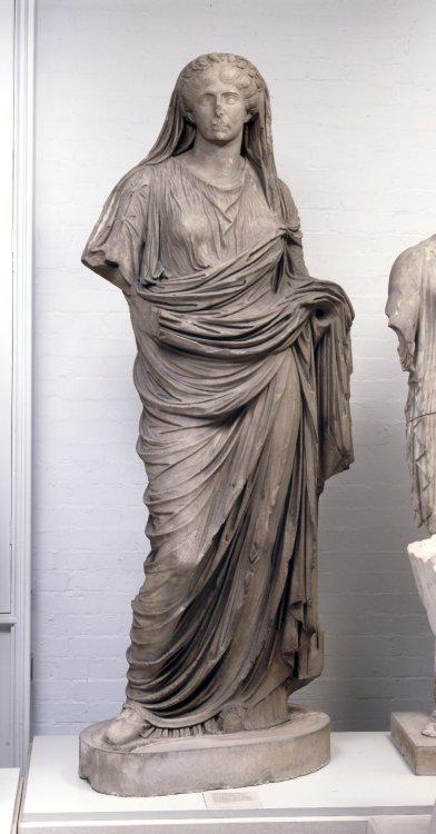 via-appia:Marble portrait statue of a veiled priestess wearing a tunic and mantle, with a wreath of 