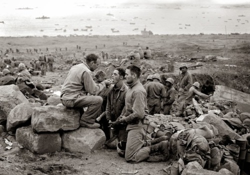 A priest giving Holy Communion to US Marines, Iwo Jima, World War II.