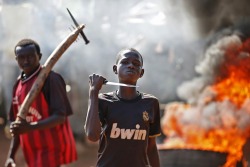 fotojournalismus:  A boy gestures in front of a barricade on fire during a protest after French troops opened fire at protesters blocking a road in Bambari on May 22, 2014. (Goran Tomasevic/Reuters) 