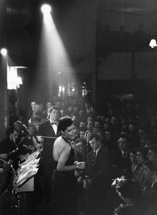 vintageeveryday:Billie Holiday in the spotlight, 1954. Photograph by Charles Hewitt.