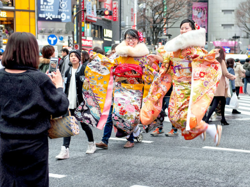 Young Japanese women celebrating Coming of Age Day (成人の日) 2018 with a big leap in the middle of Toky
