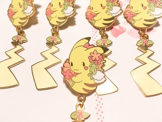 retrogamingblog:  Pikachu and Eevee dangling tail pins made by Toasterkiwi
