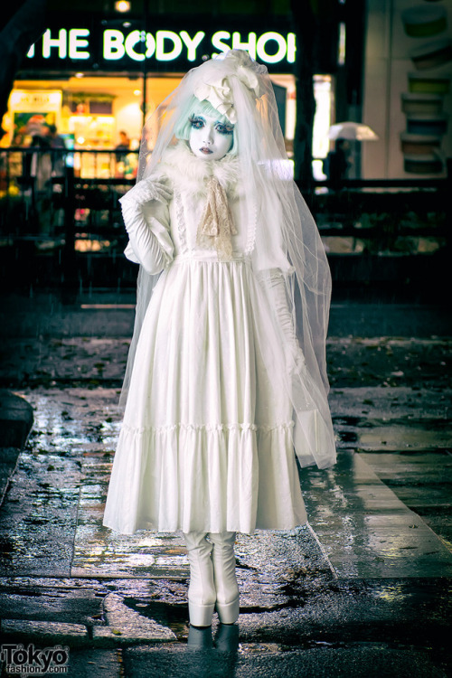 Japanese shironuri artist Minori on the street in Harajuku in the rain wearing a vintage lace dress,