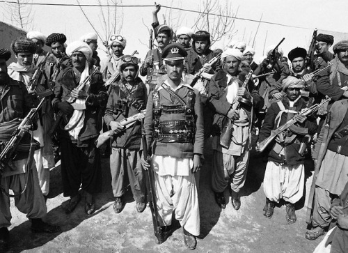 A mujahideen (a former captain in the Afghan army who had deserted)poses with a group of rebels near