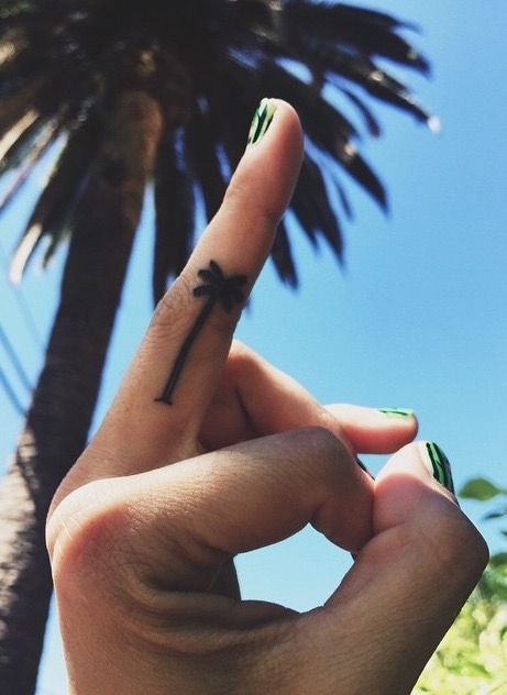 Minimalist pine tree tattoo on the finger