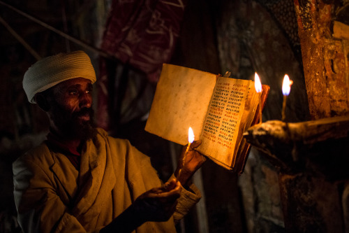 polychelles:Deacon reads the holy book by candlelight in a rock-hewn church in Gheralta, Tigray (Ant
