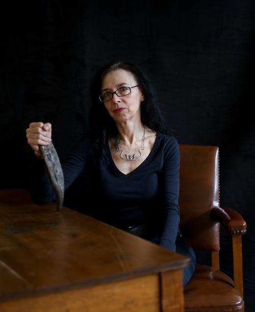 Constance Van Beek - Preparator, Fossil Invertebrates, holding the bronze cast replica of Sue’s tooth, one of a dozen especially made for the preparators who worked on her.