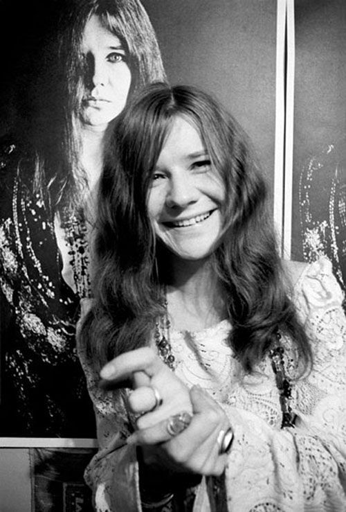 Janis posing in front of Bob Seiddmann poster, 1967.Photography by Baron Wolman.