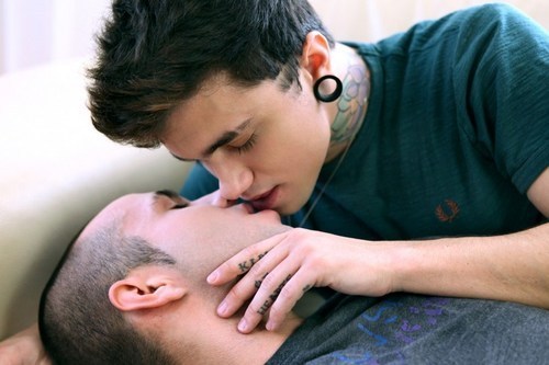 Un garçon tatoué s'apprête à embrasser son petit ami.