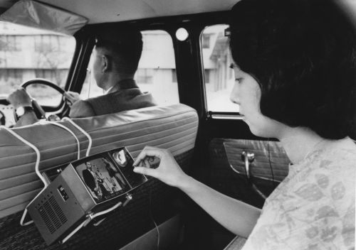vintageeveryday: A woman in Japan uses a portable micro television in the back of a car, invented by