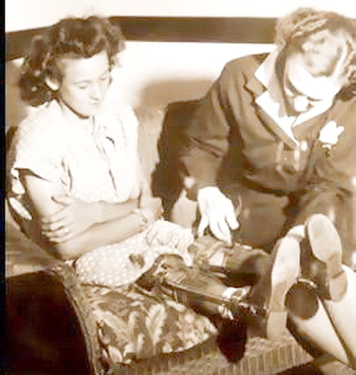 Vintage Polio braces a mother adjusts the straps on her daughter’s KAFO braces.