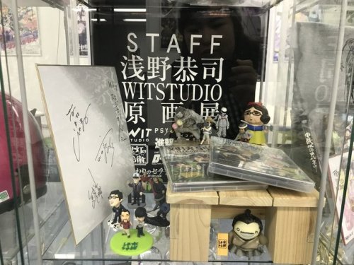 Hanamura Yaso, the author of the anime production manga, ANIMETA! (Animator!), shares photos of SnK Animation Director Asano Kyoji after meeting him at WIT Studio! Asano is posing in front of the merch display, which has plenty of SnK items.More on