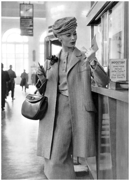 Ghislaine Arsac reading in travel ensemble by Madeleine de Rauch, hat by Svend, purse by Duc,1956. P