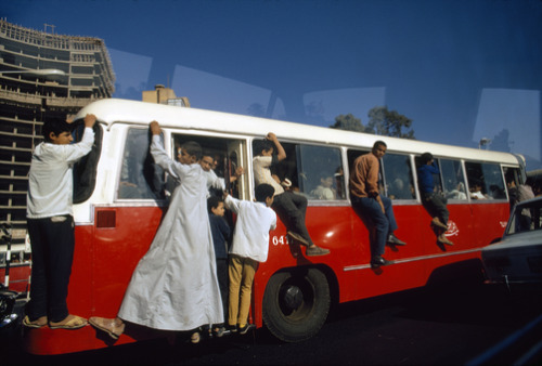 unrar:    Outriders cling to a bus in Cairo’s rush hour traffic, Egypt, Winfield Parks.