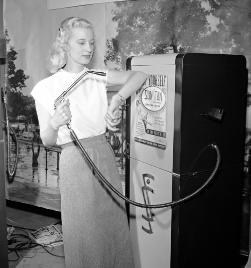 Distributeur automatique de crème auto-bronzante, 1949.Le modèle Betty Dutter présente le nouveau distributeur de lotion auto-bronzante Sun-Tan lors de la convention annuelle des distributeurs automatiques à Chicago, Illinois, le 19 janvier 1949.