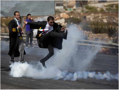 diaspora:  A Palestinian lawyer wearing his official robes kicks a tear gas canister back toward Israeli soldiers during a demonstration by scores of Palestinian lawyers called for by the Palestinian Bar Association in solidarity with protesters at the