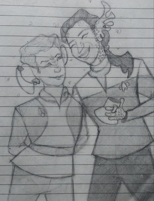 a pencil sketch of Kira and Jadzia from Deep Space 9, standing together surrounded by little hearts. Kira is a Bajoran with large mousey ears, a ridged nose, and short hair. She has her arms behind her back and is smiling up at Jadzia, a Trill with axolotl-like frills for ears, spots down her neck and arms, and long hair in a ponytail pulled over her shoulder. Jadzia is laughing and holding a raktajino mug in a spotty, four-fingered hand.